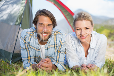 Attractive couple smiling at camera from inside their tent