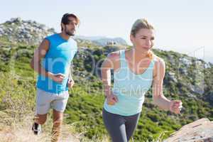 Fit couple jogging through countryside