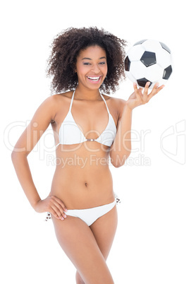 Athletic girl in white bikini holding football