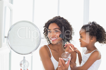 Pretty mother teaching her daughter about makeup