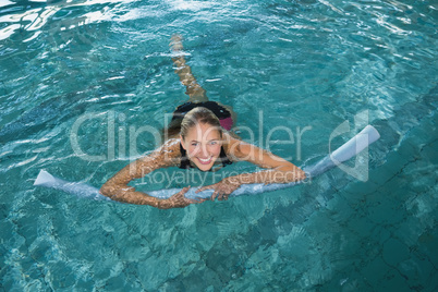 Fit blonde swimming with foam roller