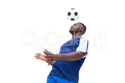 Football player in blue heading ball