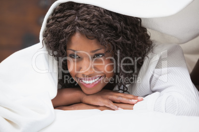 Attractive woman smiling under the duvet