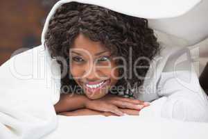 Attractive woman smiling under the duvet