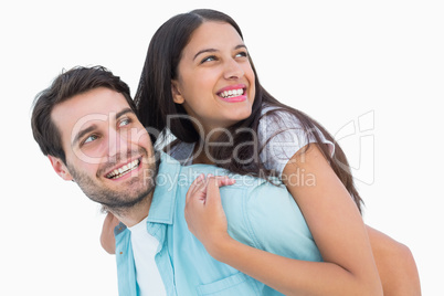 Happy casual man giving pretty girlfriend piggy back