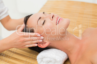 Smiling brunette enjoying a head massage