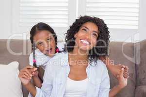 Pretty mother sitting on the couch with her daughter