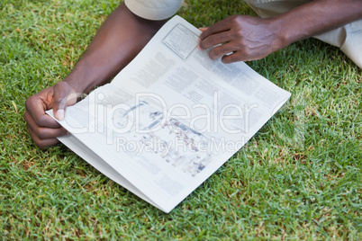Man relaxing in his garden reading newspaper