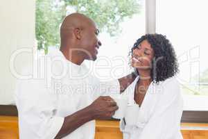 Happy couple having coffee together in bathrobes