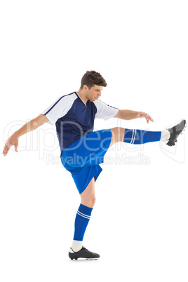 Football player in blue jersey kicking