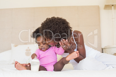 Happy parents with baby girl on their bed