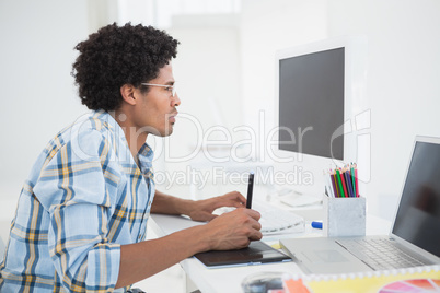 Young designer working at his desk with digitizer