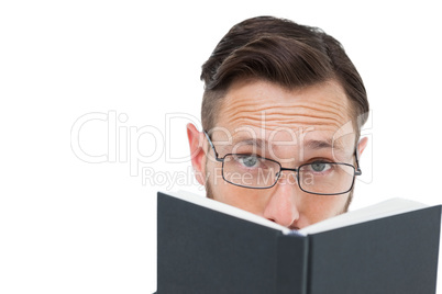 Young geek looking over black book