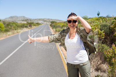 Pretty hitchhiker sticking thumb out on the road