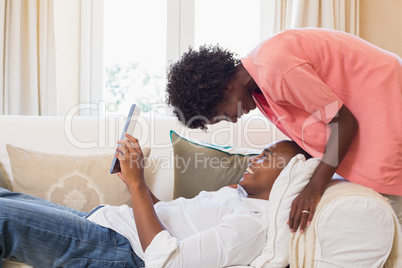 Cute couple relaxing on couch with tablet pc Cute couple relaxing on couch with tablet pc
