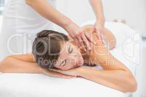 Attractive woman receiving shoulder massage at spa center