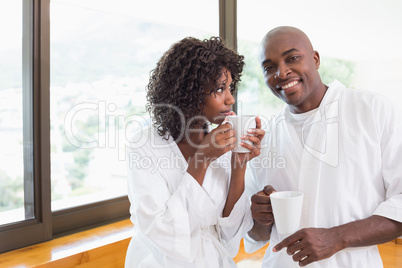 Happy couple having coffee together in bathrobes