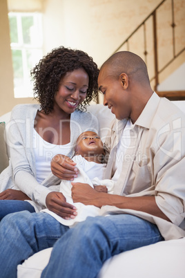 Happy parents spending time with baby on the couch