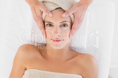 Attractive woman receiving facial massage at spa center