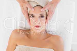Attractive woman receiving facial massage at spa center