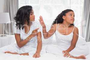 Mother and daughter having an argument on bed