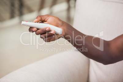 Man holding remote control on couch