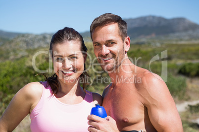 Active couple smiling at camera in the countryside