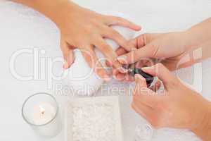 Beautician applying nail varnish to female clients nails