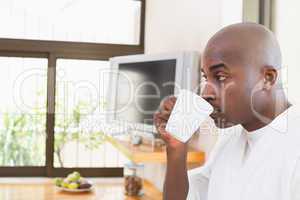 Happy man in bathrobe drinking coffee