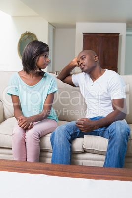 Unhappy couple not talking after argument on sofa