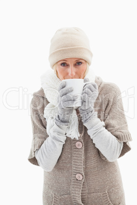 Mature woman in winter clothes holding mug