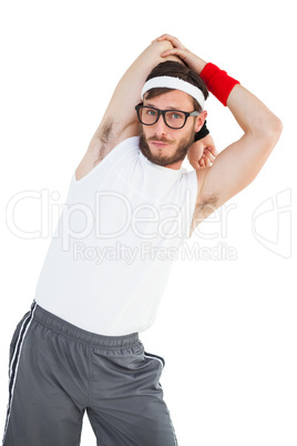 Geeky hipster stretching in sportswear