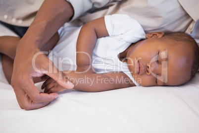 Happy father napping with baby son on couch