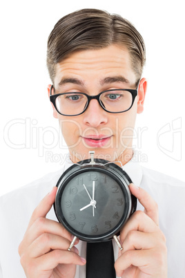 Geeky businessman holding alarm clock