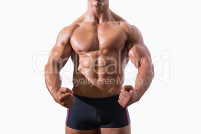 Mid section of a muscular young man clenching fists