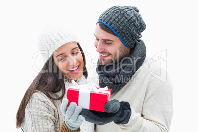 Attractive young couple in warm clothes holding gift