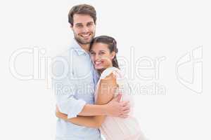 Attractive young couple hugging and smiling at camera