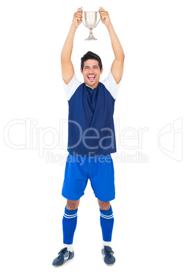 Football player in blue holding winners cup