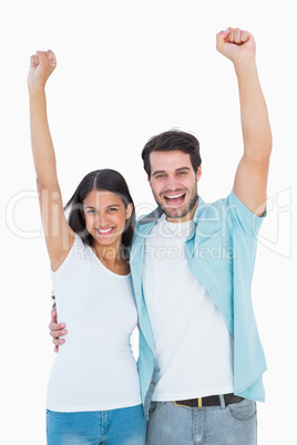 Happy casual couple cheering together Happy casual couple cheering together