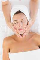 Attractive woman receiving facial massage at spa center