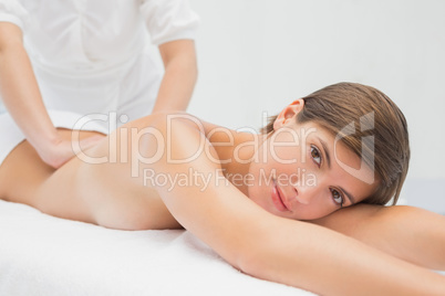 Attractive young woman receiving back massage at spa center