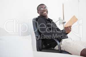 Casual man sitting on swivel chair reading a book