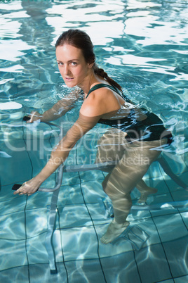 Fit brunette using underwater exercise bike