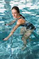 Fit brunette using underwater exercise bike