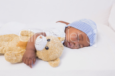 Adorable baby boy sleeping peacefully with teddy