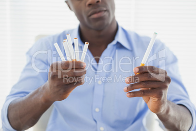 Businessman deciding between electronic or normal cigarettes
