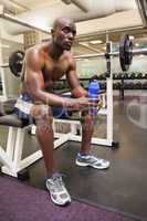 Muscular man with energy drink in gym