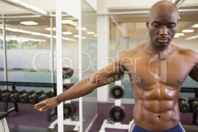 Serious shirtless muscular man in gym