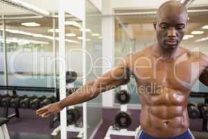 Serious shirtless muscular man in gym