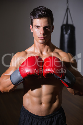 Shirtless muscular boxer in defensive stance